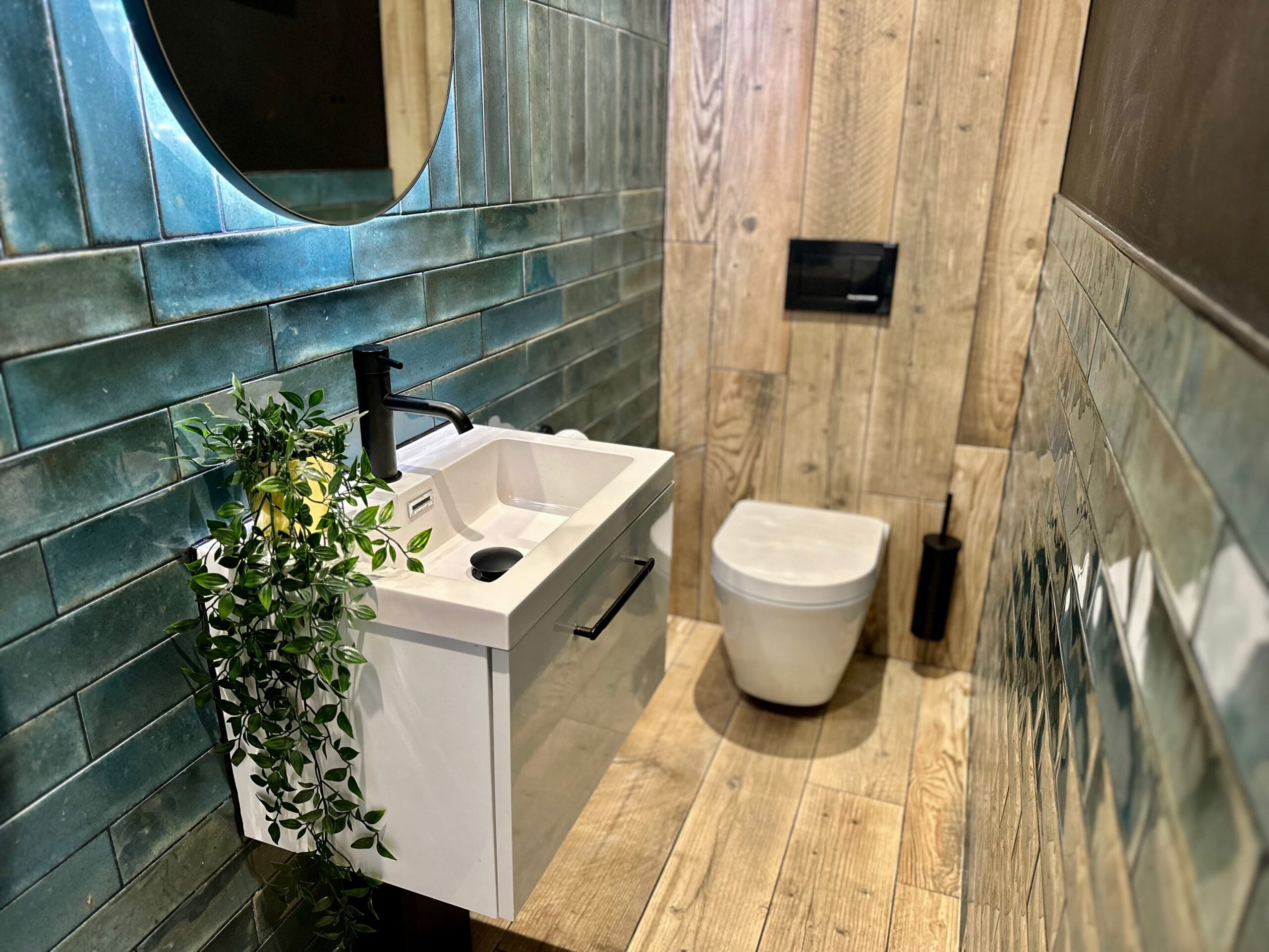 Bathroom guest toilet with green tiles and wooden element at Mor Interiors in Cornwall Truro